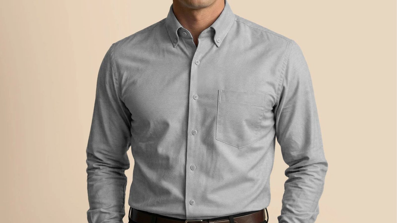 A man in a gray shirt and brown pants, exuding effortless style and sophistication.