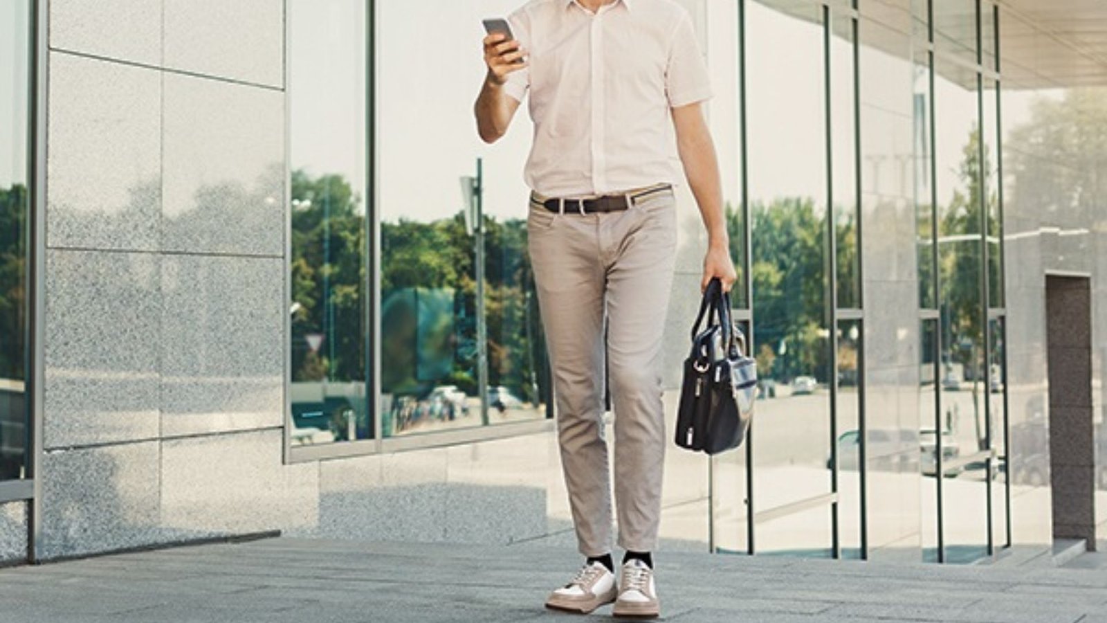 Man in beige dress pants and white sneakers showing a casual outfit