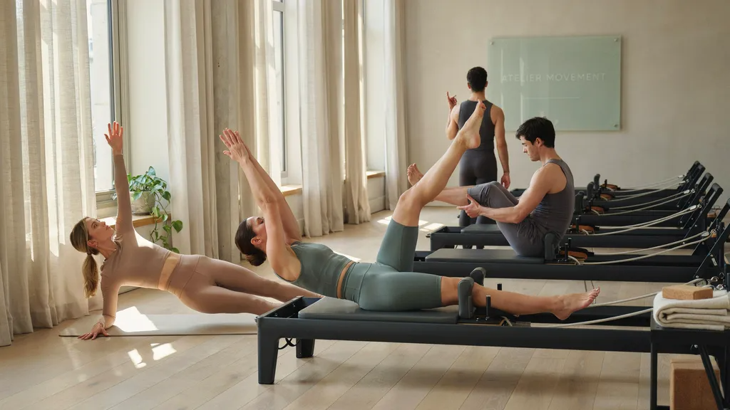 Pilates class in minimalist fitted activewear in a bright studio.