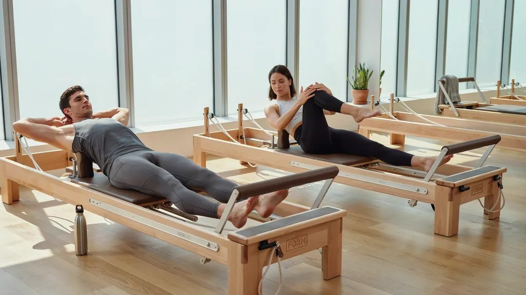People doing strength Pilates in compression leggings and fitted tops.