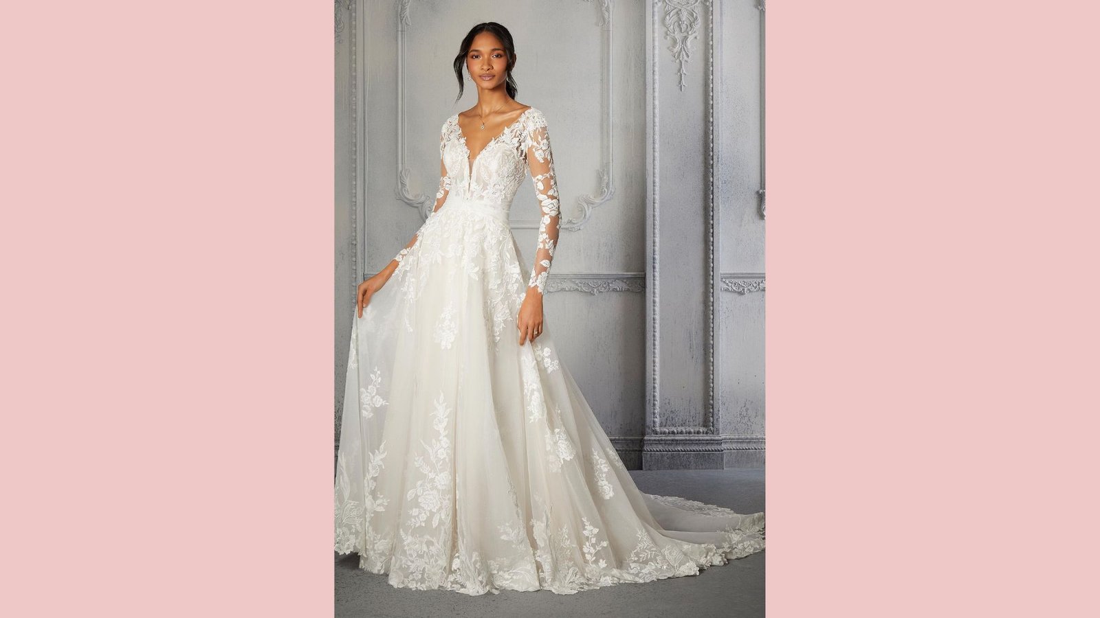 Bride in romantic A-line gown with sheer lace sleeves, deep V-neckline, floral appliqués, full skirt, cathedral train, elegant