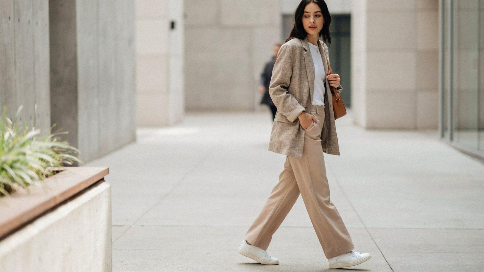 "Woman styling wide leg pants with an oversized blazer and sneakers for a smart casual outfit"