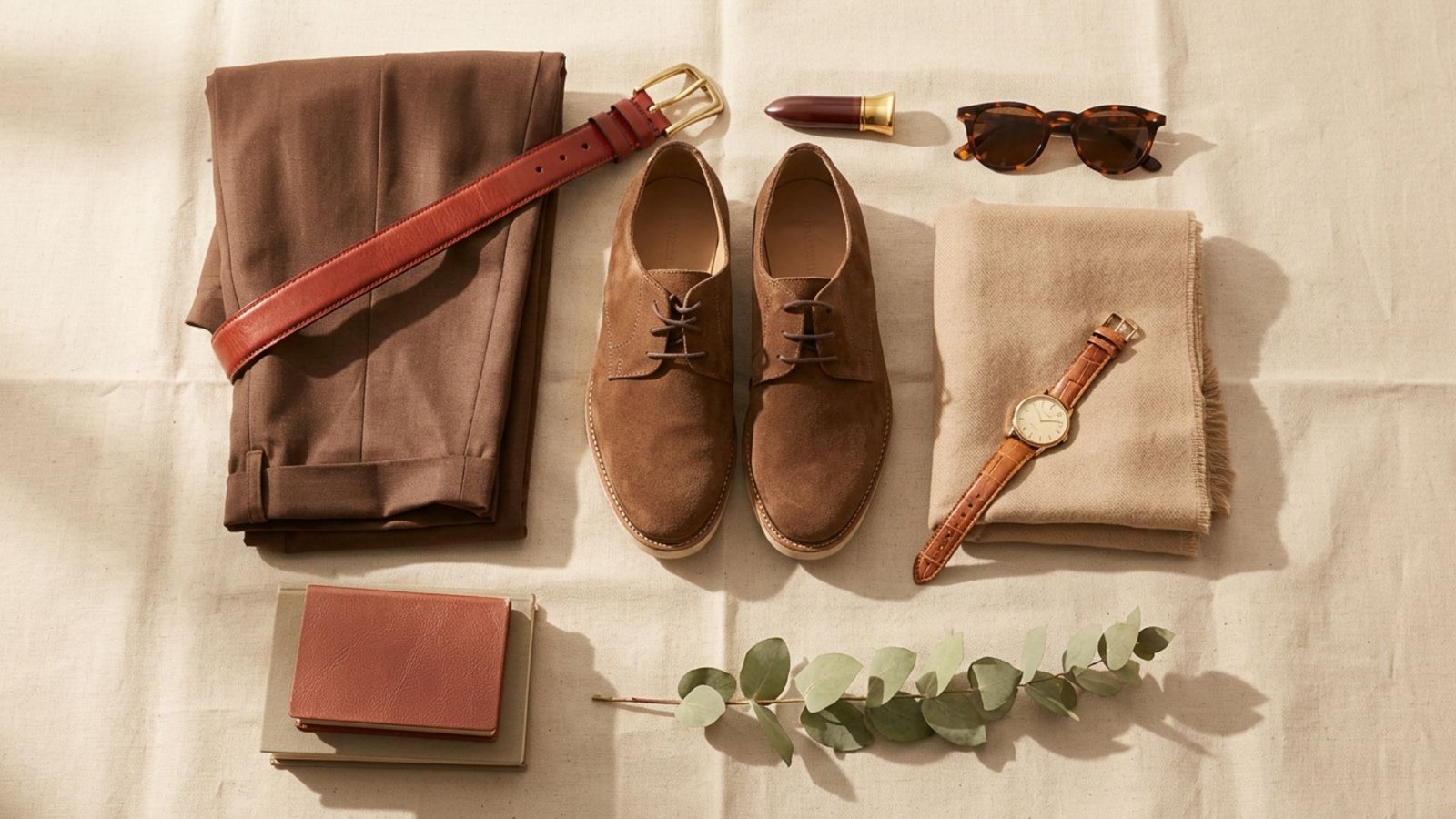 Clothing and accessories arranged on a table, highlighting items that match brown pants.