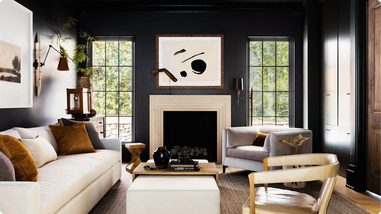 Modern living room with black walls, white sofas, and mustard accent pillows.
