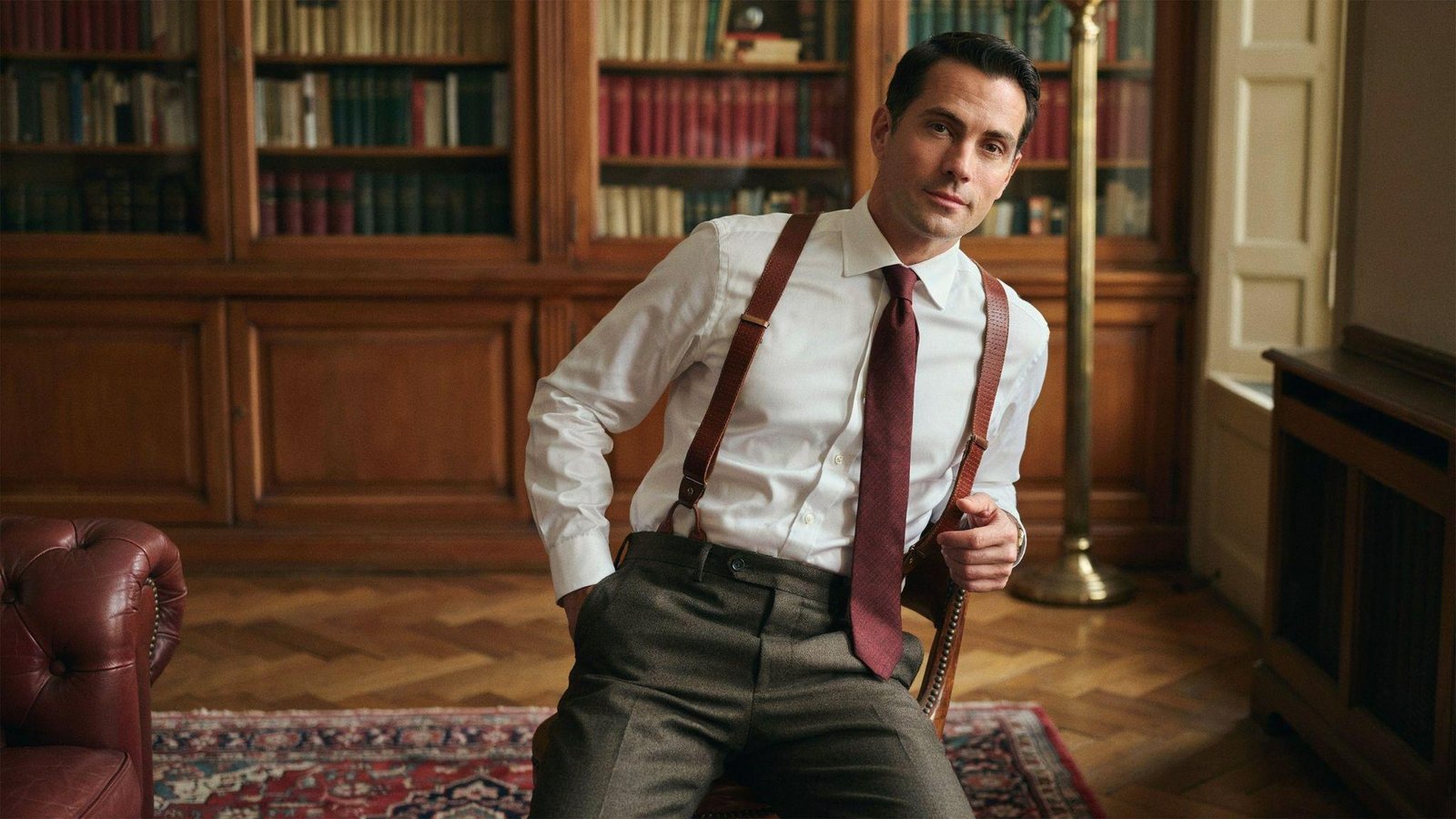 "Man wearing suspenders with high-waisted trousers and button-down shirt in retro 80s formal style"