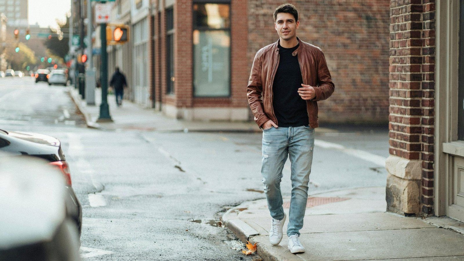 "Man wearing acid wash jeans with a basic black tee and leather jacket in modern 80s-inspired fashion"