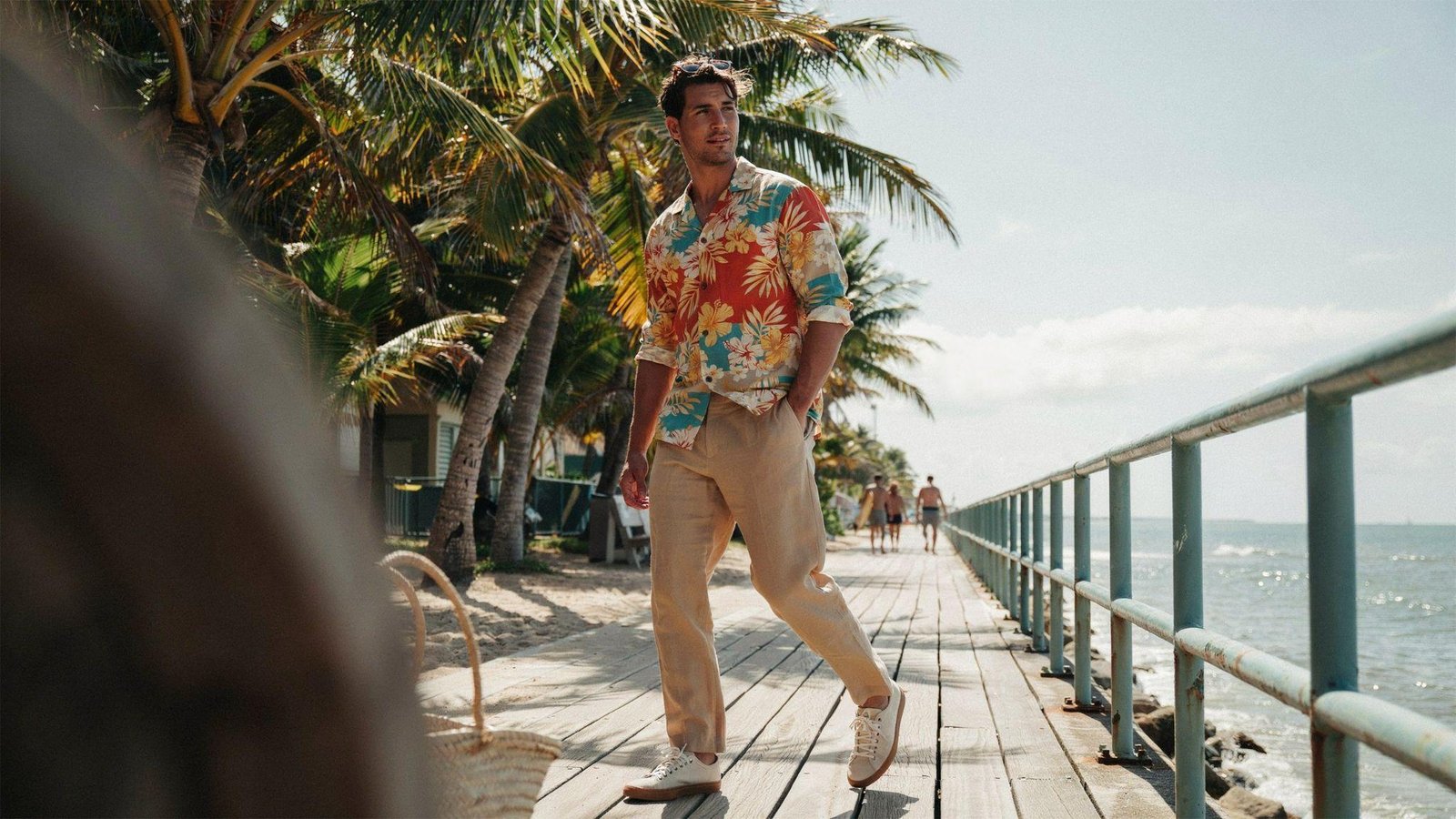 "Man wearing printed Hawaiian shirt with relaxed linen pants in an easy 80s-inspired summer outfit"