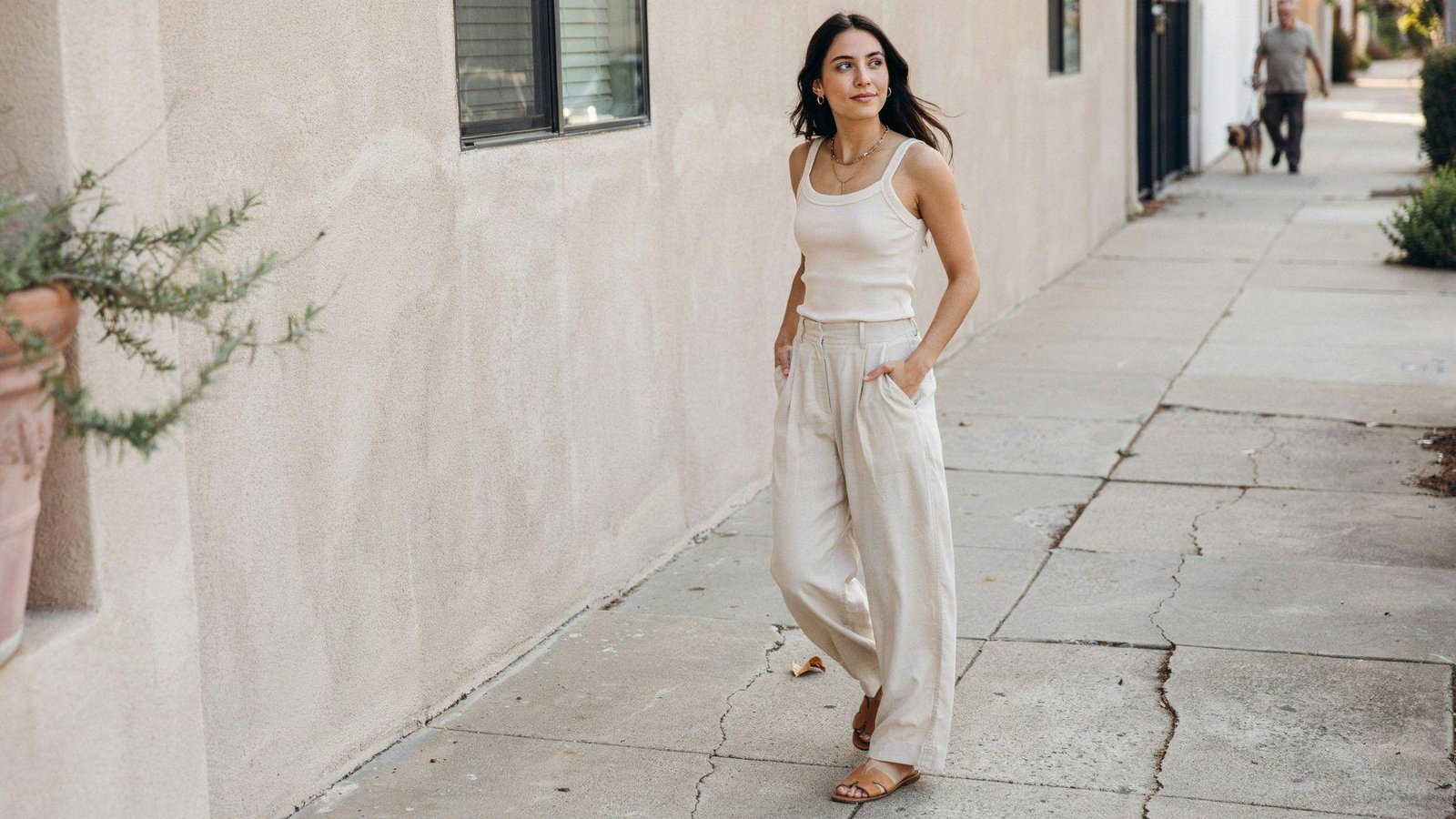"Woman styling wide leg pants with a fitted tank top for a relaxed summer casual outfit"