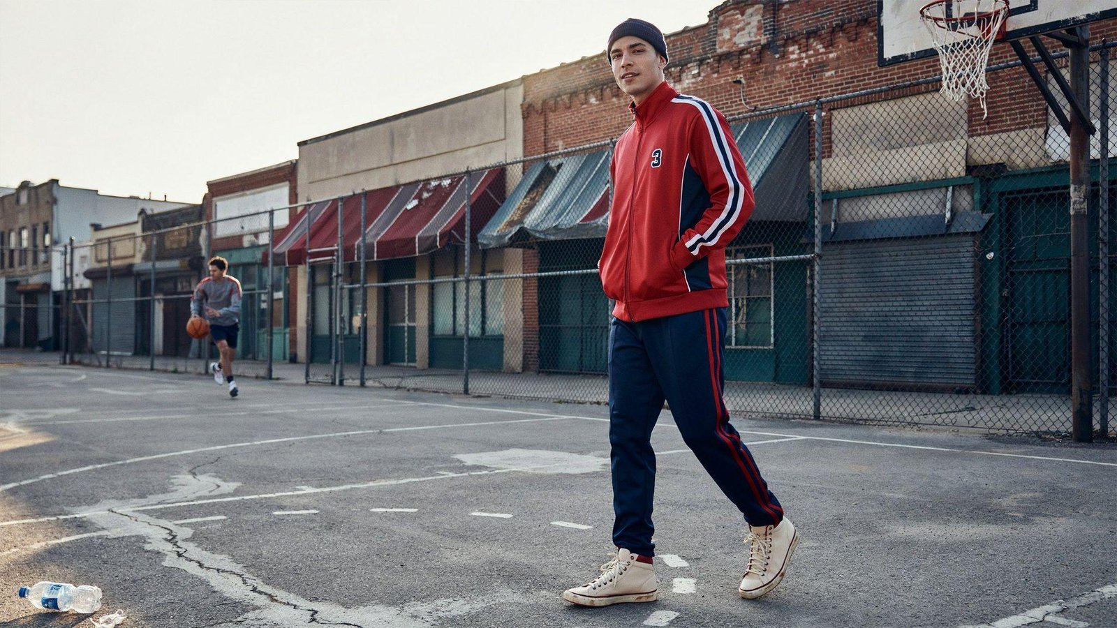 "Man wearing matching retro tracksuit with vintage trainers in classic 80s sportswear style"
