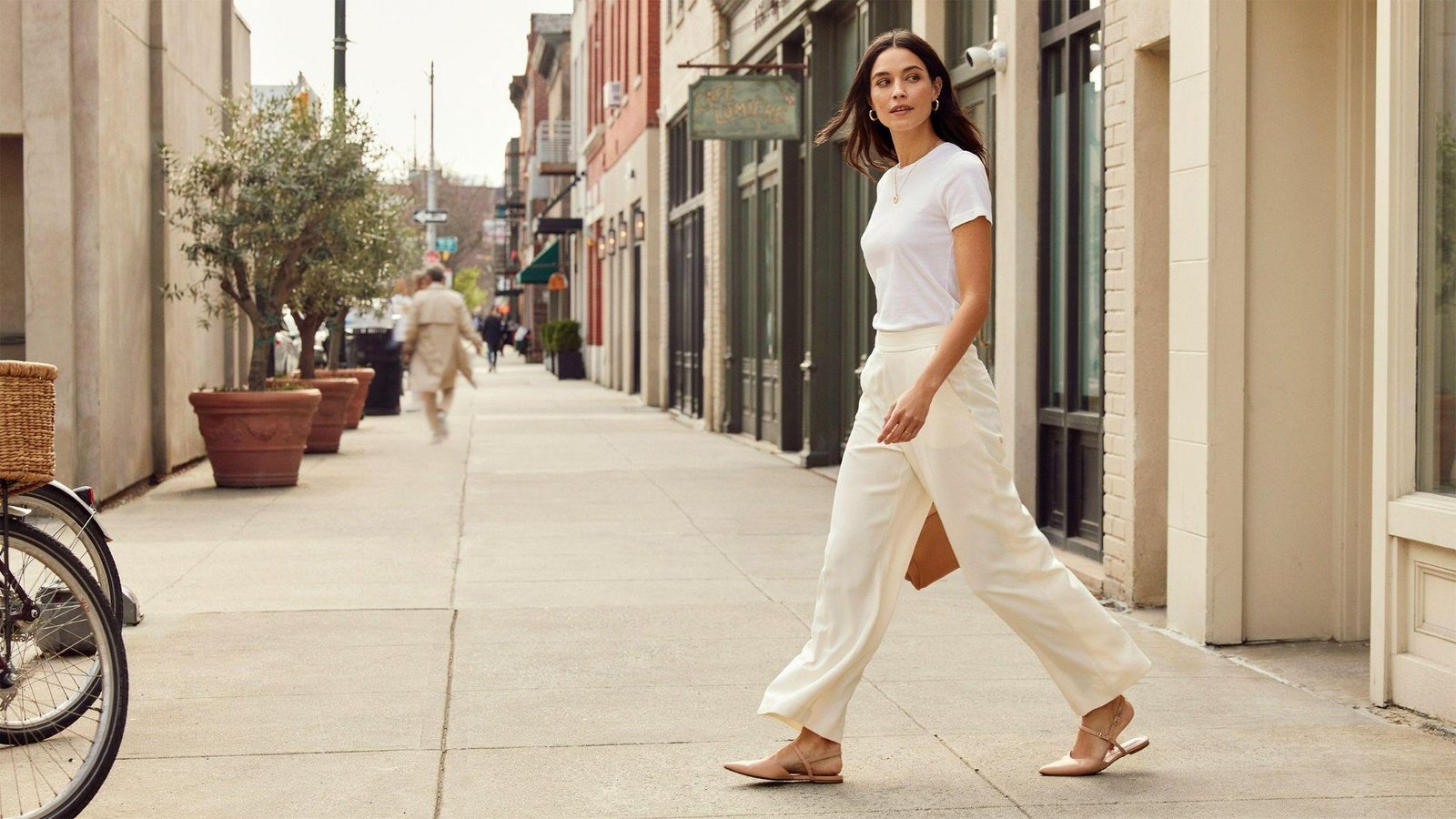 "Woman wearing stylish wide leg pants with a casual white tee on a modern city street"