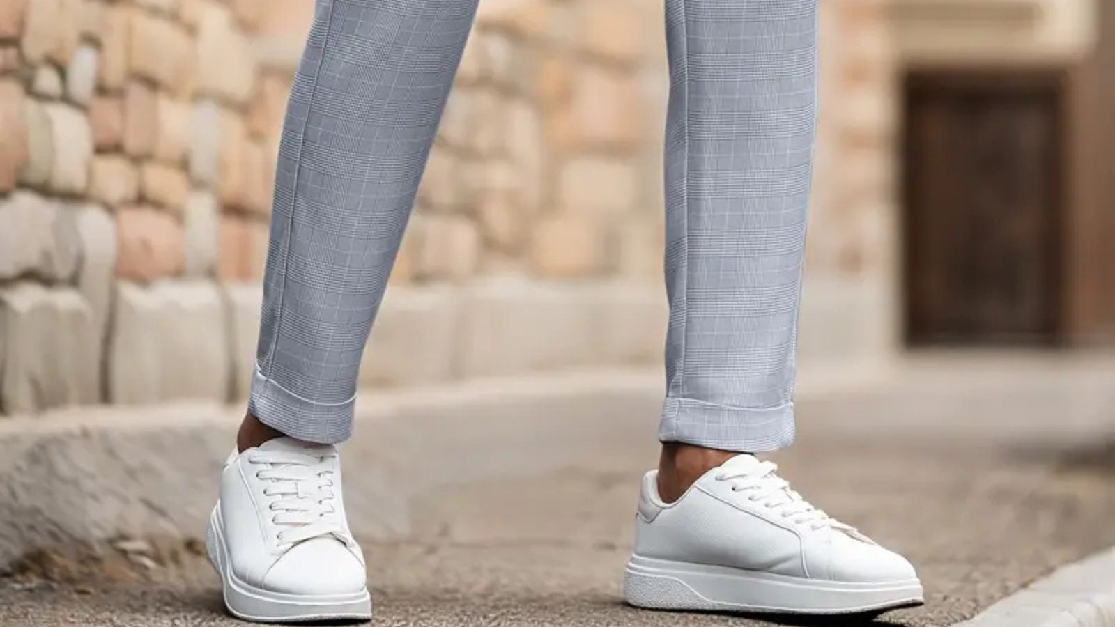 Close-up of slim-fit light grey dress pants paired with clean white casual sneakers