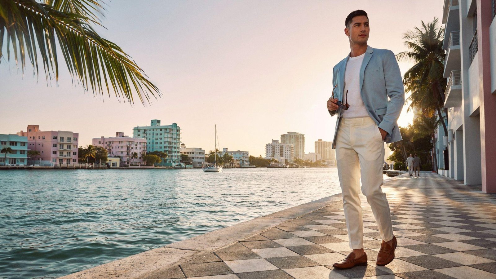 "Man wearing pastel blazer with white t-shirt and tailored trousers in a modern Miami Vice-inspired outfit"
